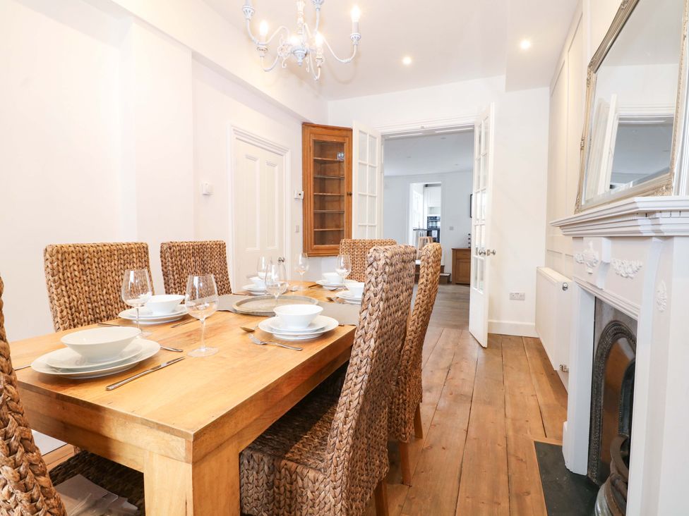 A dining room with a wooden table set for dinner at 19 Queen Street in Emsworth