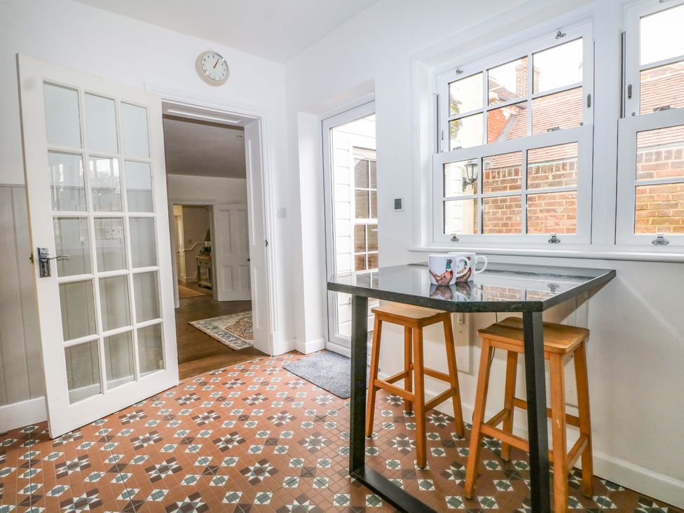 A kitchen with a table and stools at 19 Queen Street Emsworth