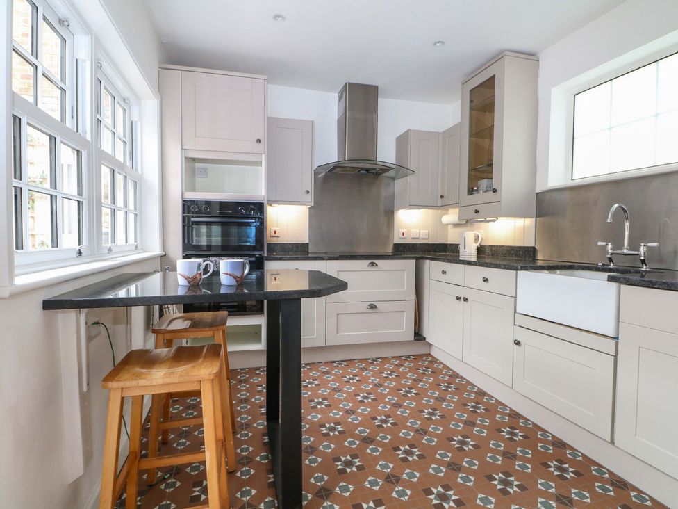 A kitchen with a counter, oven, and sink at 19 Queen Street in Emsworth