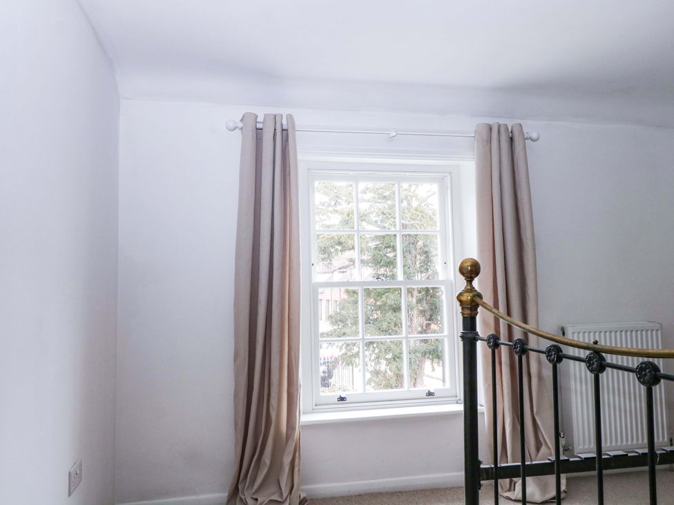 A bedroom with a window and curtains at 19 Queen Street Emsworth