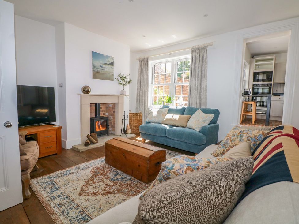 A living room with a blue sofa and a fireplace at 19 Queen Street in Emsworth
