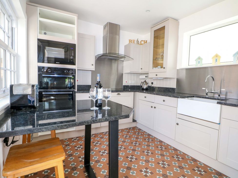 A kitchen with a sink, oven, and microwave at 19 Queen Street in Emsworth