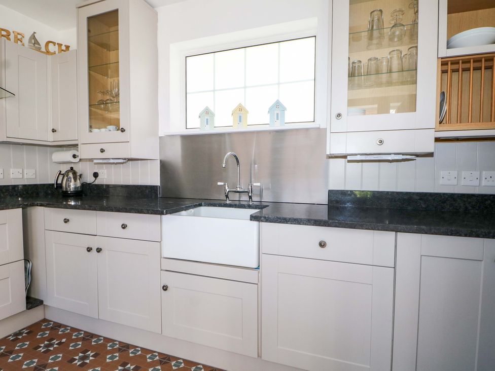 A kitchen with a sink and cupboards at 19 Queen Street in Emsworth