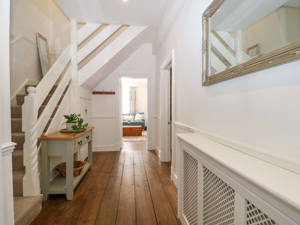 A hallway with a staircase and console table at 19 Queen Street Emsworth