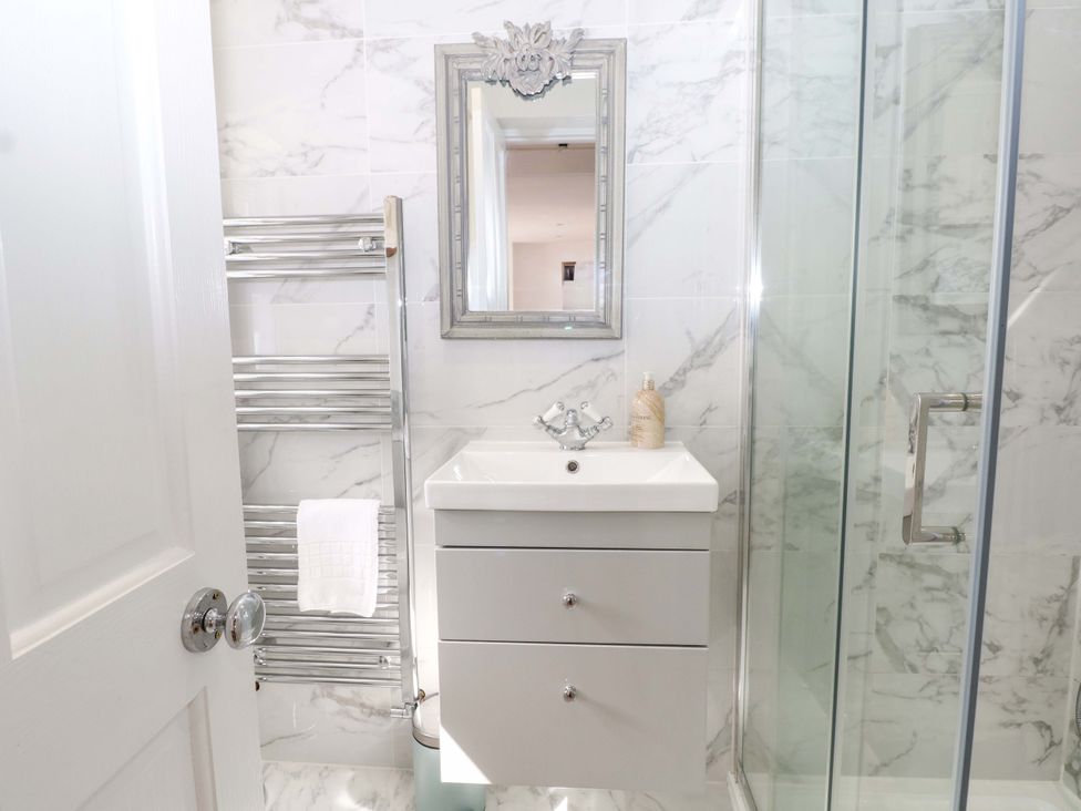 A bathroom with a sink, towel rack, and shower at 19 Queen Street Emsworth
