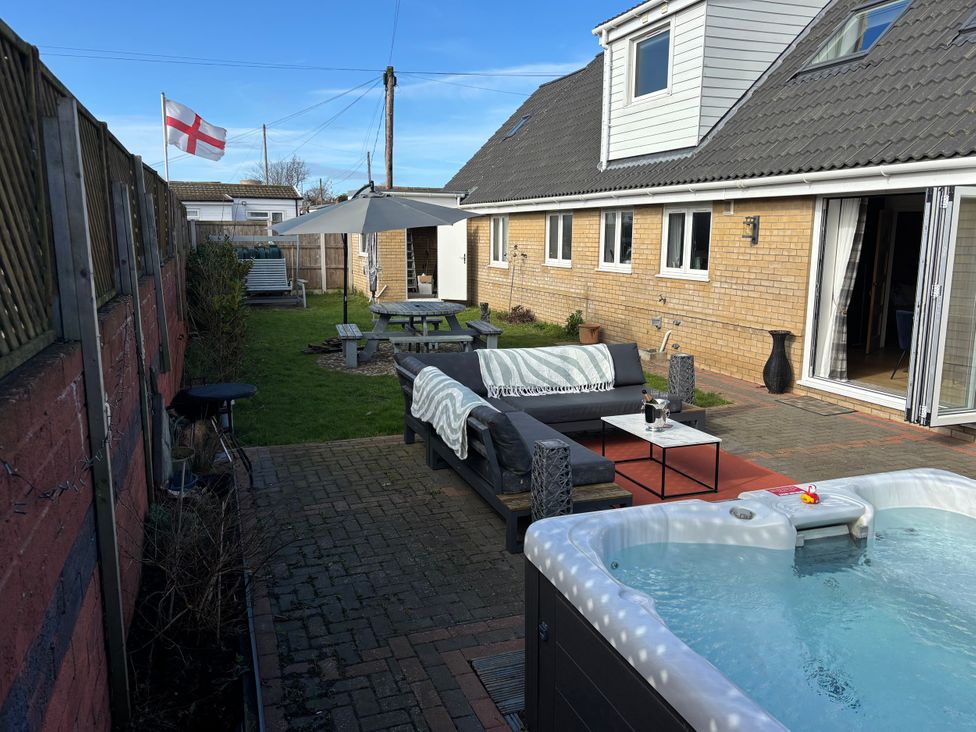A garden with a hot tub and outdoor seating at Seaview in Pakefield