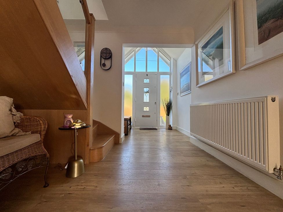 A hallway with a front door and artwork at Seaview in Pakefield