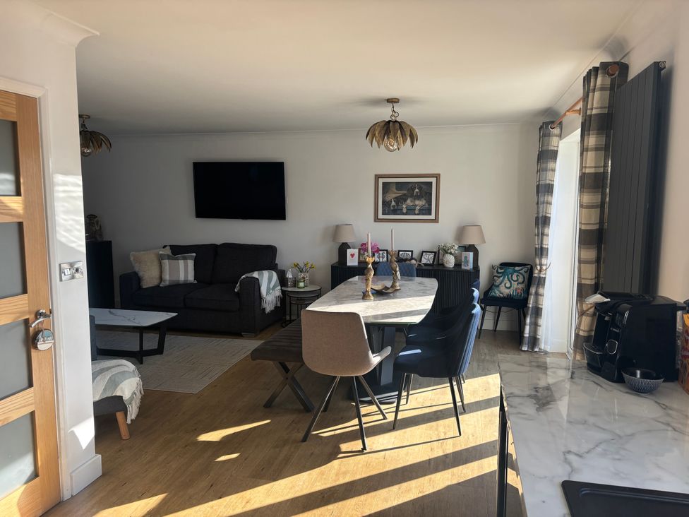 A living room with a sofa and dining table at Seaview in Pakefield