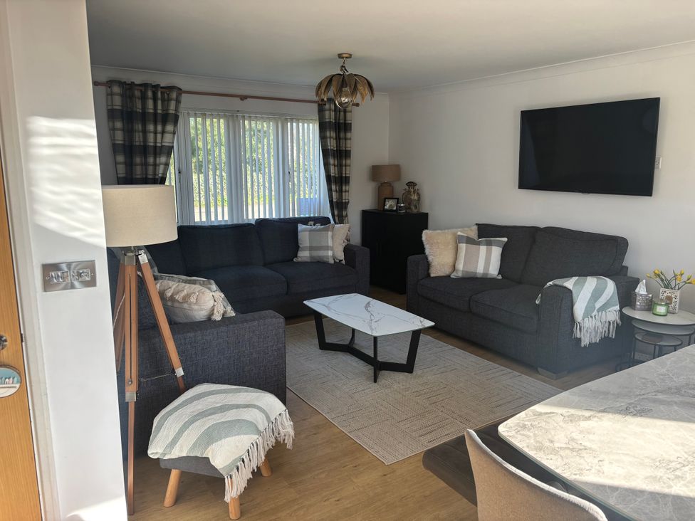 A living room with a sofa and television at Seaview in Pakefield