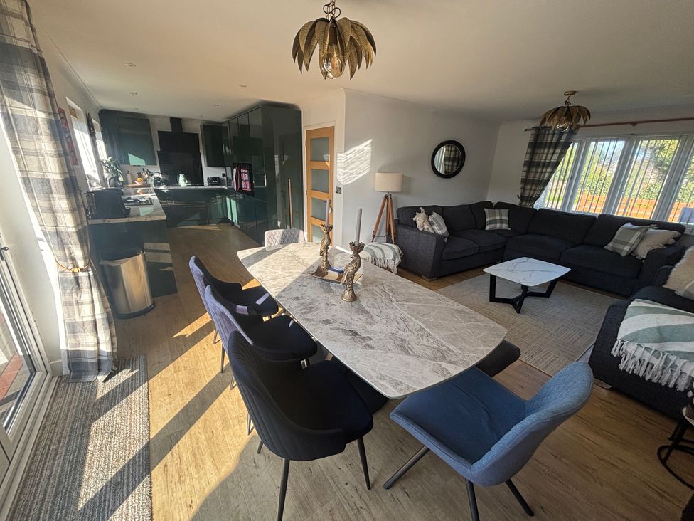 A dining room with a marble table and sofa at Seaview in Pakefield