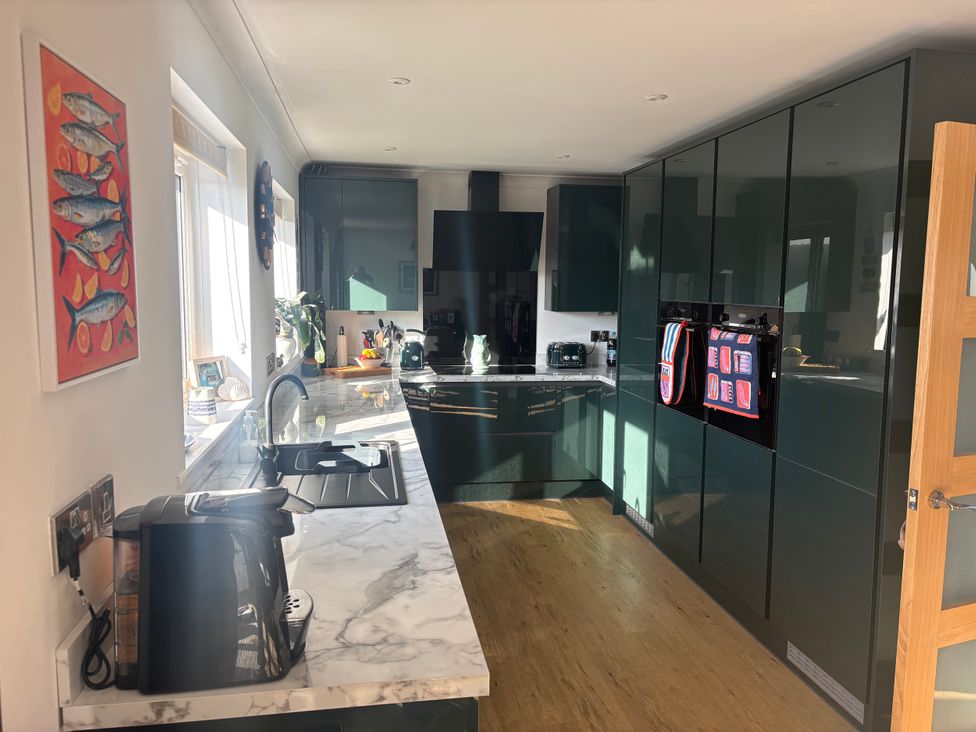 A kitchen with modern appliances and a marble countertop at Seaview in Pakefield