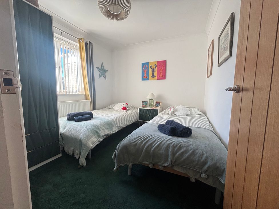 A bedroom with two beds and decorative art at Seaview in Pakefield