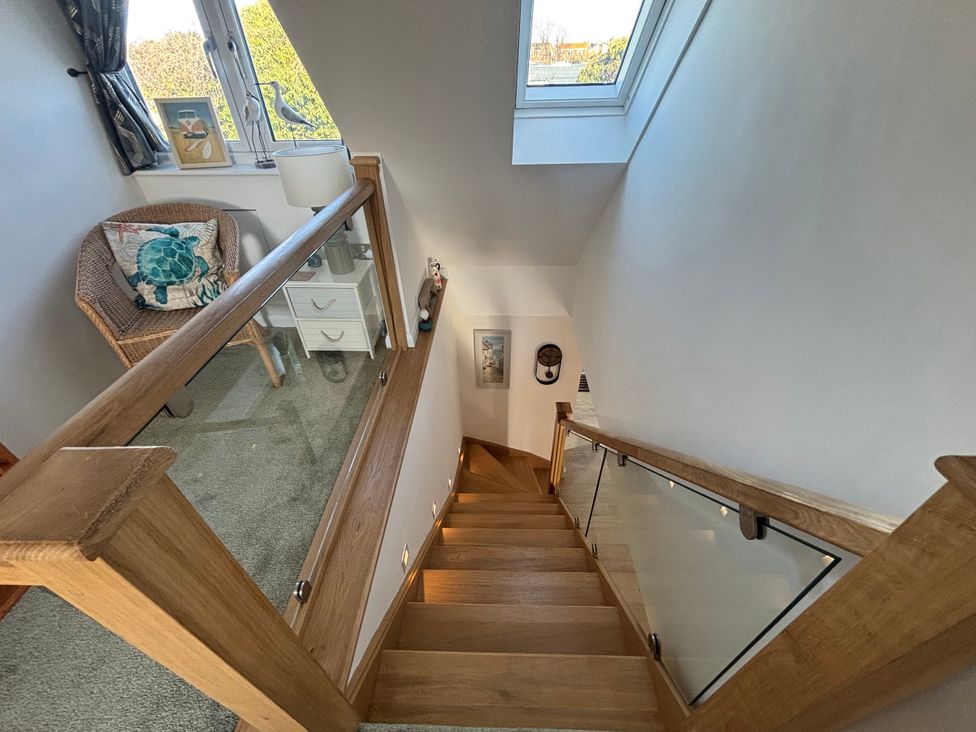 A staircase with a window and a chair at Seaview in Pakefield