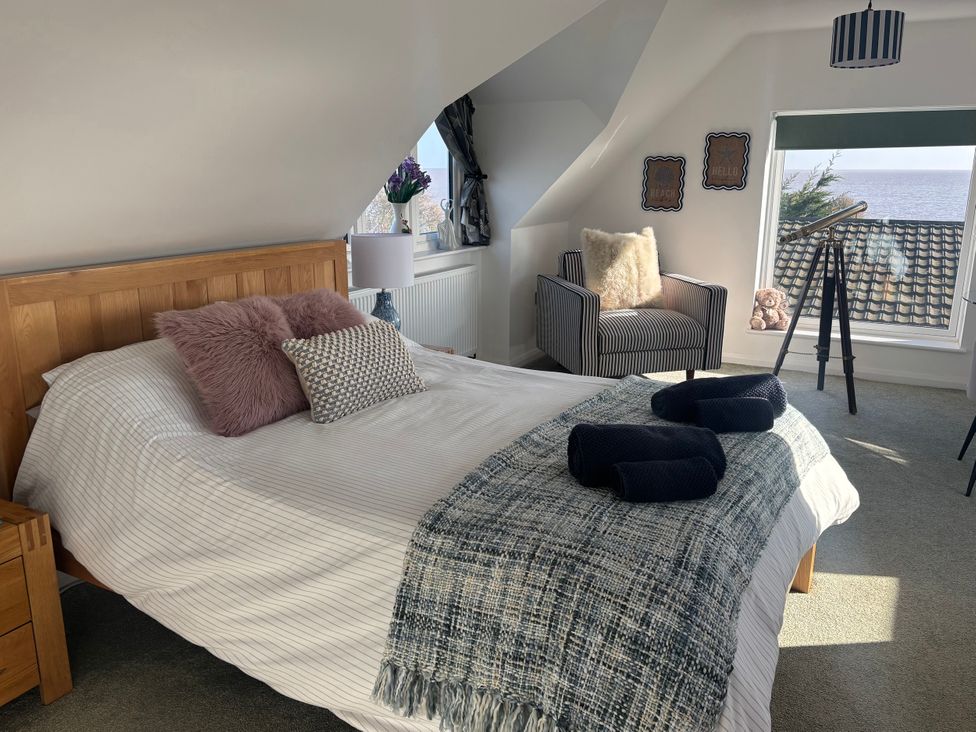 A bedroom with a bed and telescope at Seaview in Pakefield