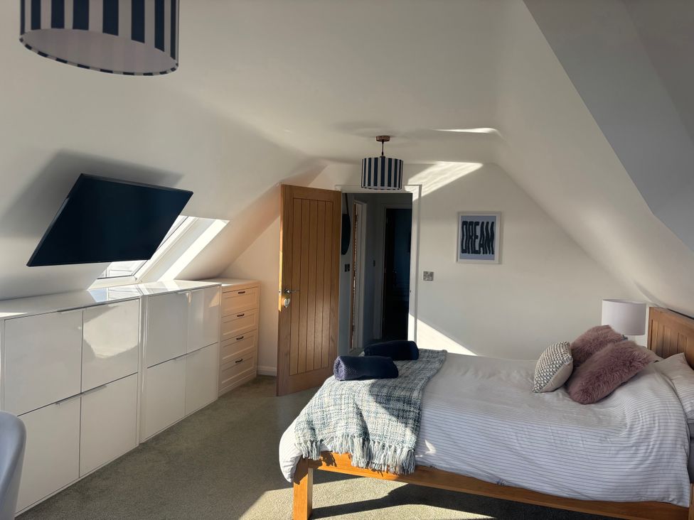 A bedroom with a bed and television at Seaview in Pakefield