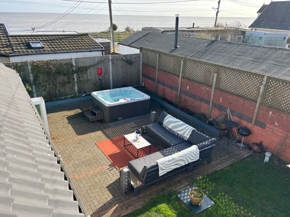 A garden with a hot tub and patio furniture at Seaview in Pakefield
