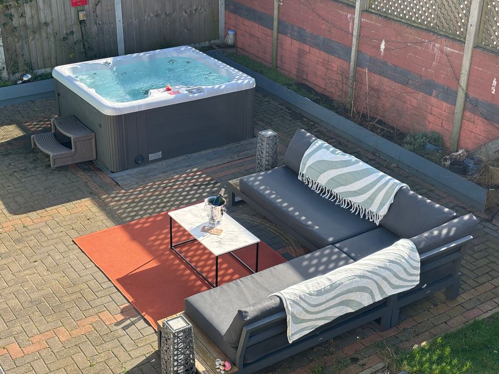 A garden with a hot tub and outdoor seating at Seaview in Pakefield