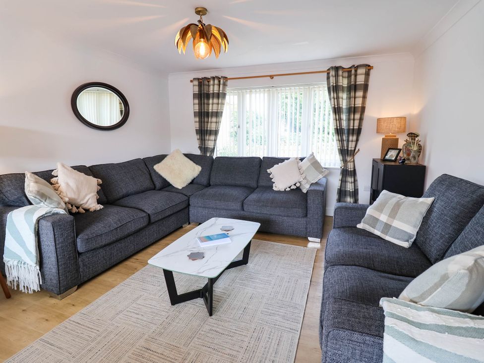 A living room with a sectional sofa and coffee table at Seaview in Pakefield