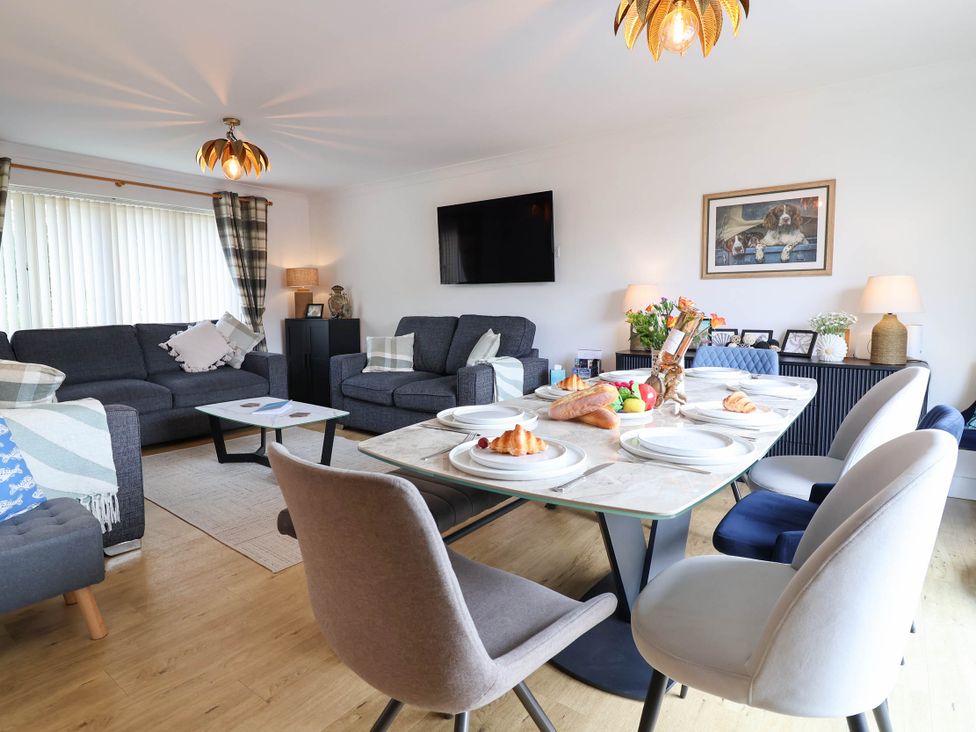 A living room with a dining table and sofa at Seaview in Pakefield