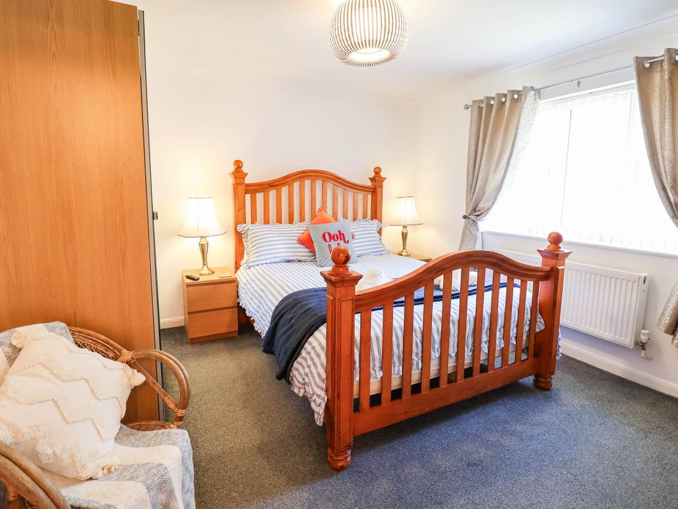 A bedroom with a bed and nightstand at Seaview in Pakefield