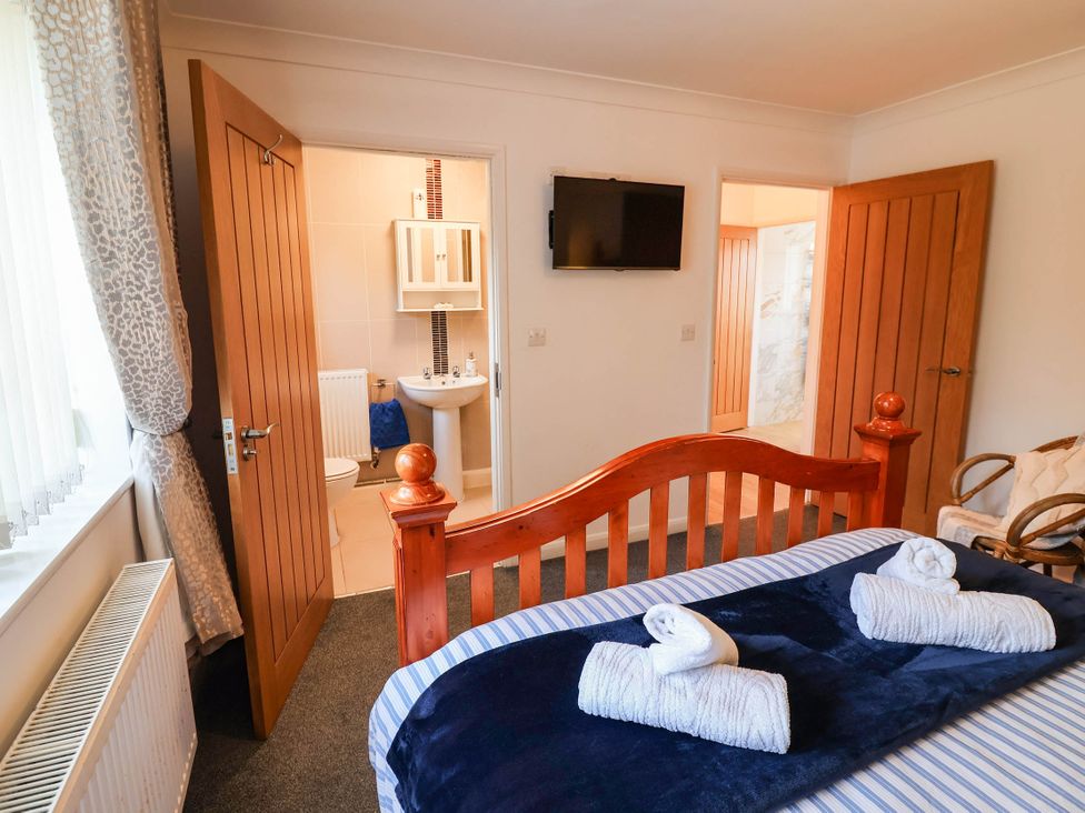 A bedroom with a bed and television at Seaview in Pakefield