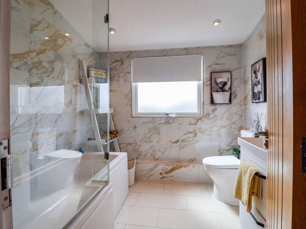 A bathroom with a bathtub, toilet, and sink at Seaview in Pakefield