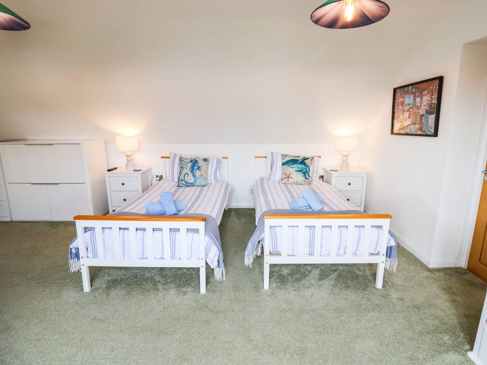 A bedroom with two beds and a nightstand at Seaview in Pakefield