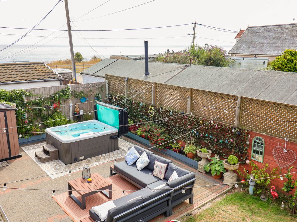 A garden with a hot tub and sitting area at Seaview in Pakefield