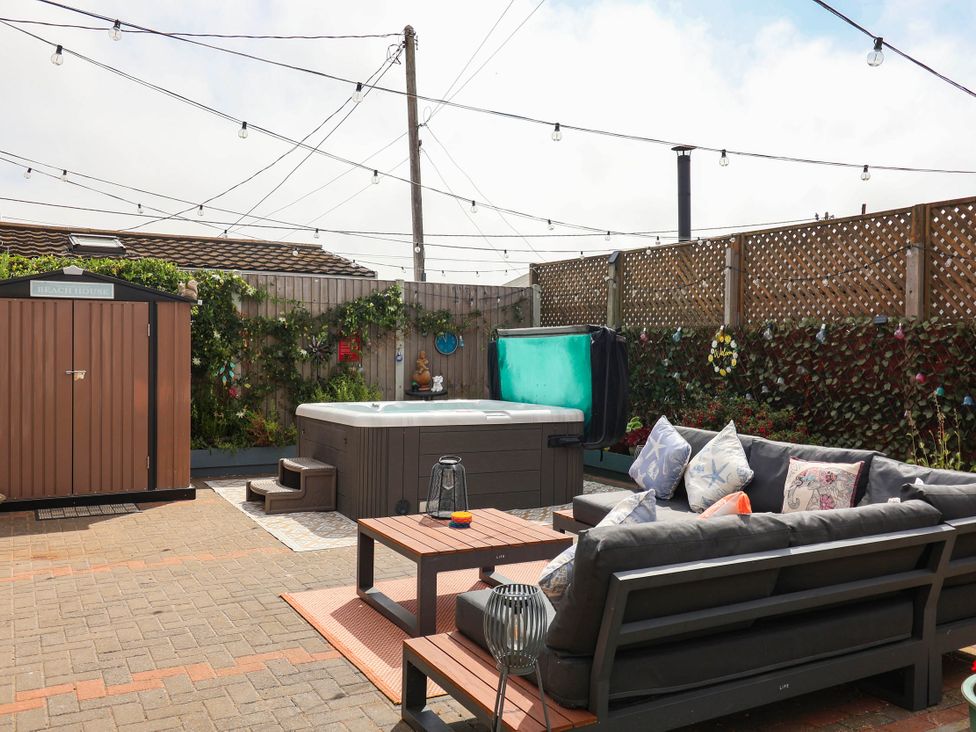 An outdoor area with a hot tub and seating at Seaview in Pakefield