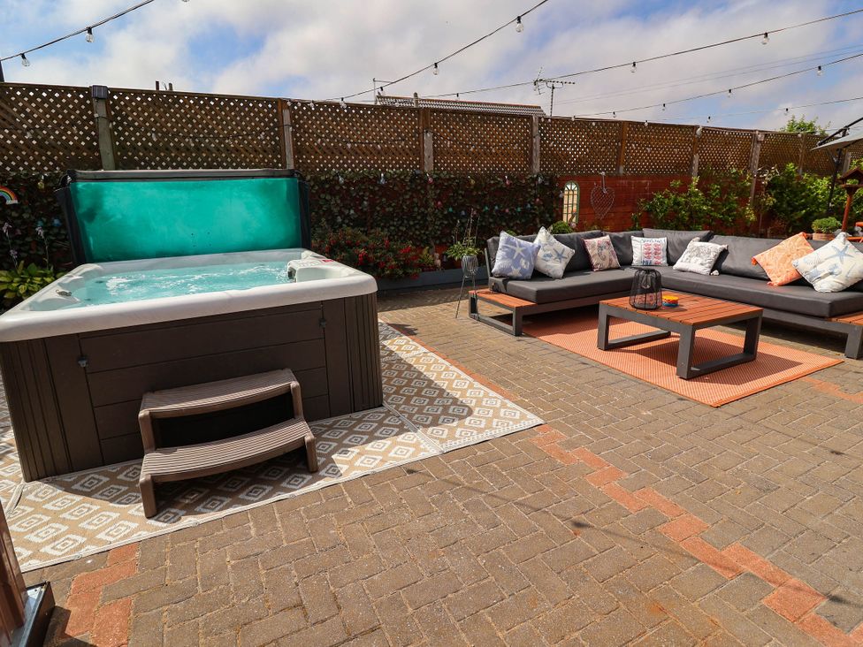 An outdoor area with a hot tub and seating at Seaview in Pakefield