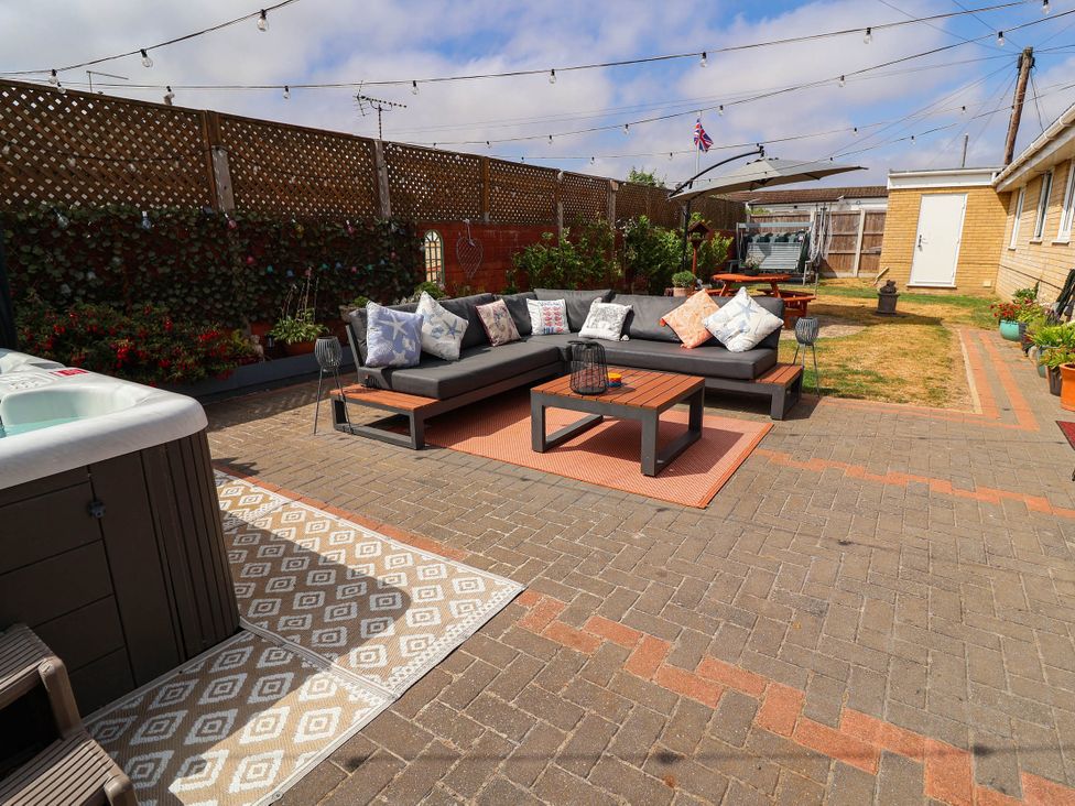 A garden with a seating area and hot tub at Seaview in Pakefield
