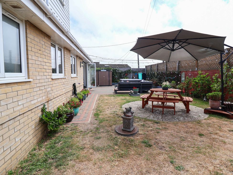 A garden with a patio table and umbrella at Seaview in Pakefield