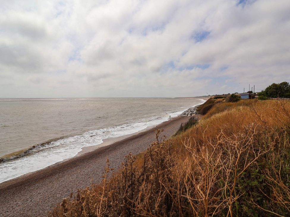 A beach shoreline with rocks and grass near the ocean at Seaview in Pakefield