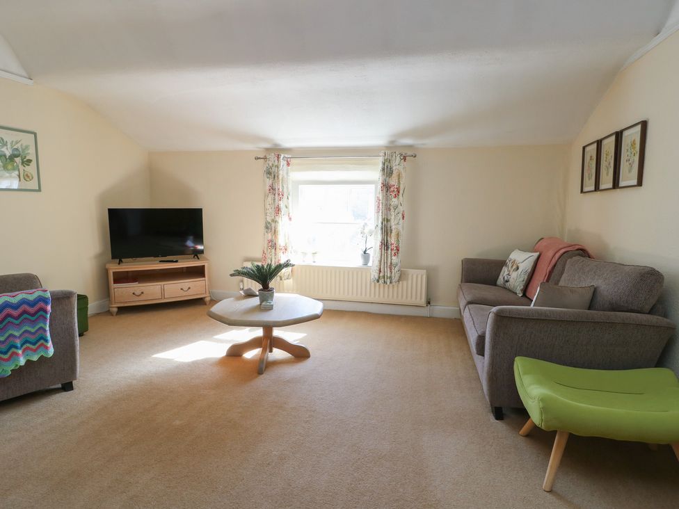 A living room with a television and sofa at Castle Gardens Apartment Beaumaris