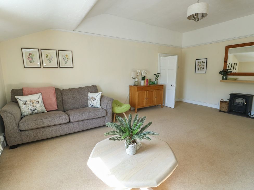 A living room with a sofa and coffee table at Castle Gardens Apartment Beaumaris