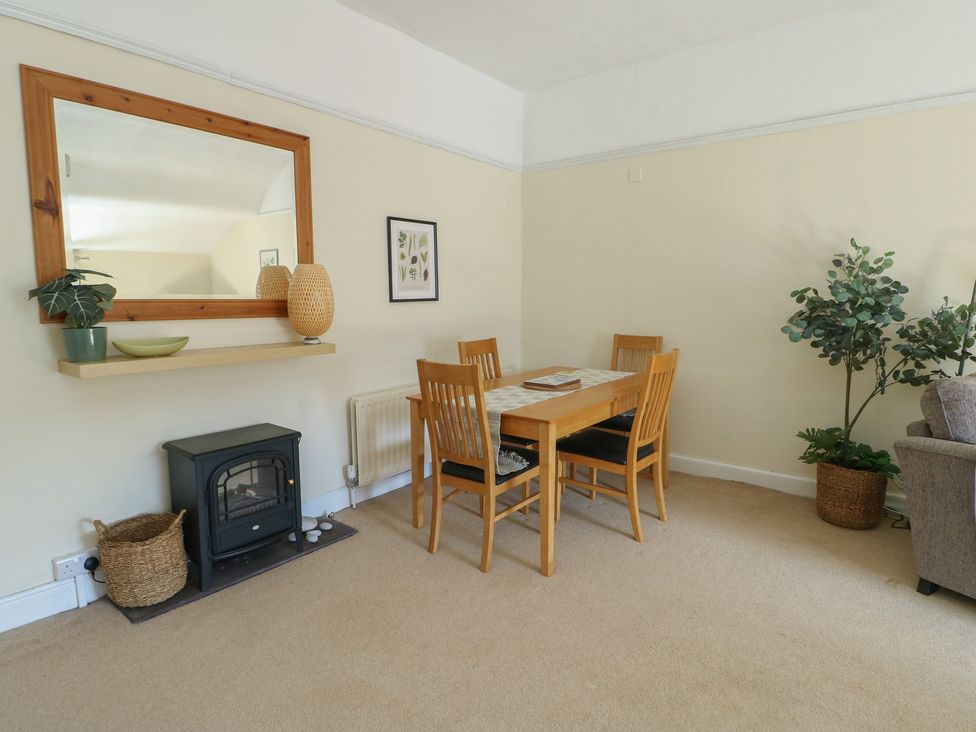 A dining room with a table and chairs at Castle Gardens Apartment in Beaumaris