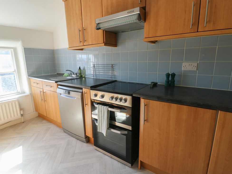 A kitchen with cabinets and appliances at Castle Gardens Apartment Beaumaris
