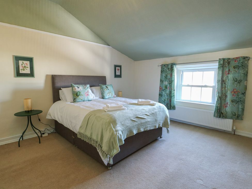 A bedroom with a bed and bedside table at Castle Gardens Apartment Beaumaris
