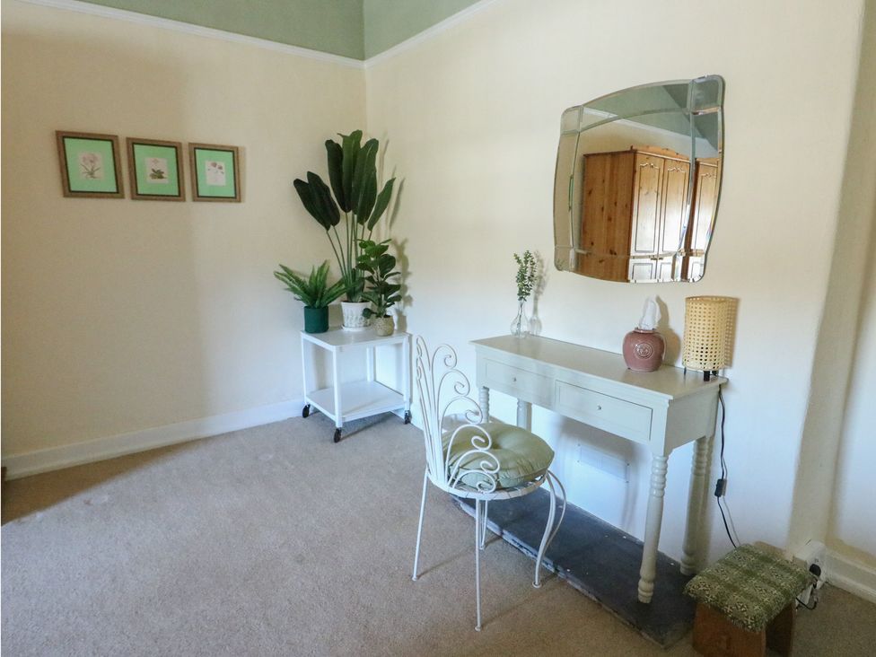 A room with a table and chair in Castle Gardens Apartment Beaumaris