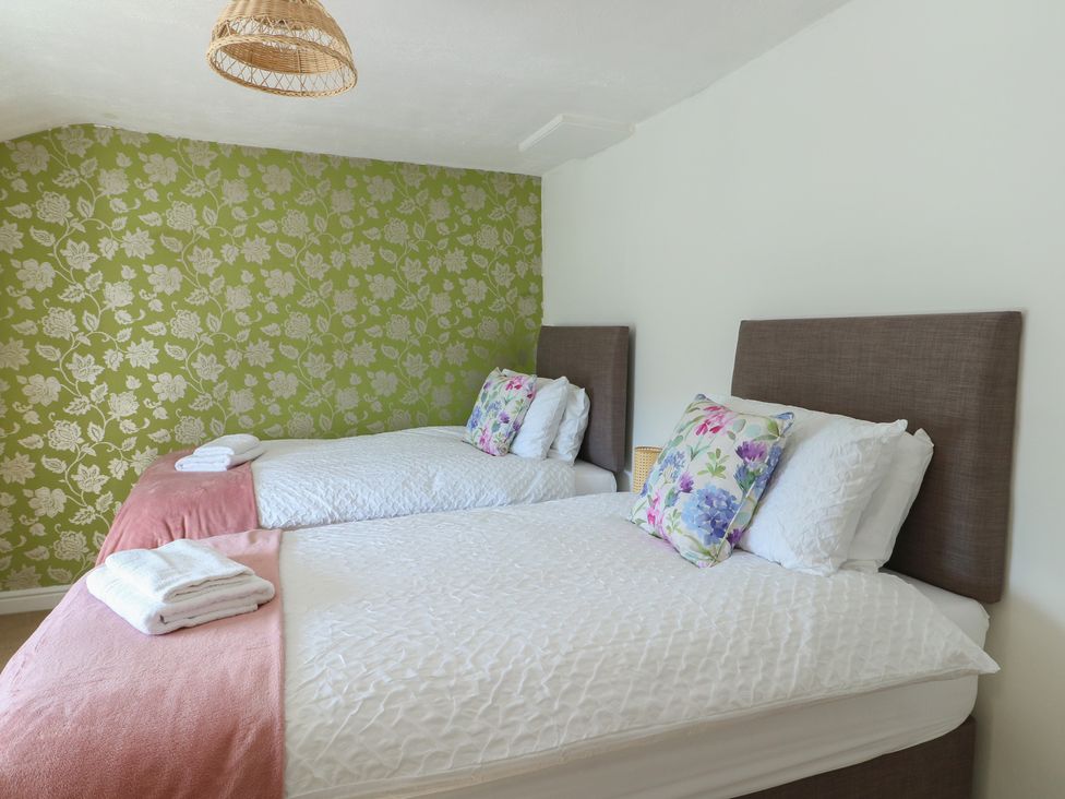A bedroom with two beds and stylish pillows at Castle Gardens Apartment Beaumaris
