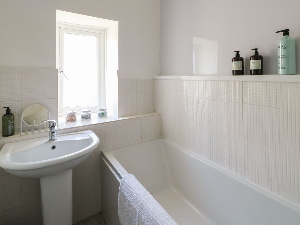 A bathroom with a sink and tub at Castle Gardens Apartment Beaumaris