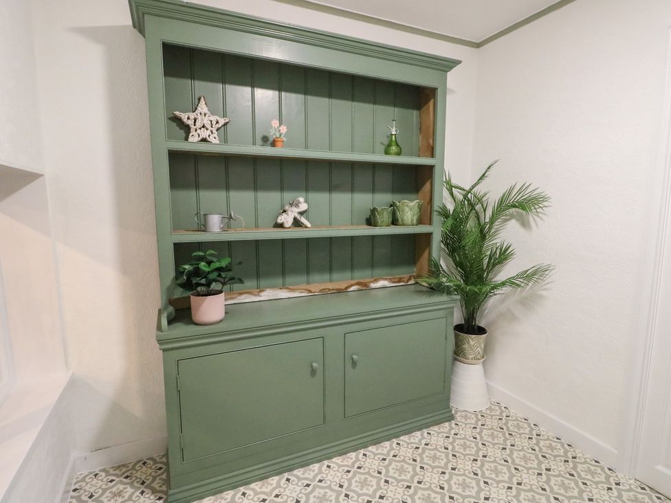 A shelf with decorative items and a plant at Castle Gardens Apartment Beaumaris