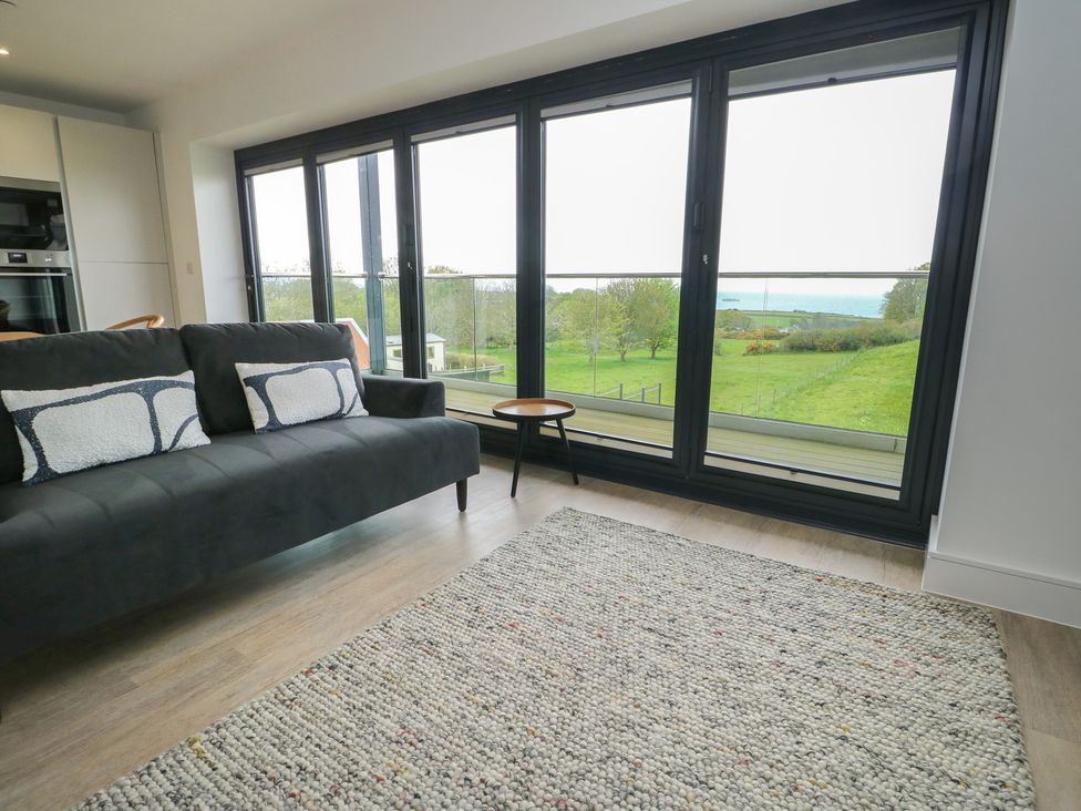 A living room with a sofa and table at Glynllifon 5 Marian-glas near Benllech