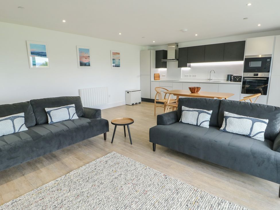 A living room with sofas and a dining area at Glynllifon 5 Marian-glas near Benllech