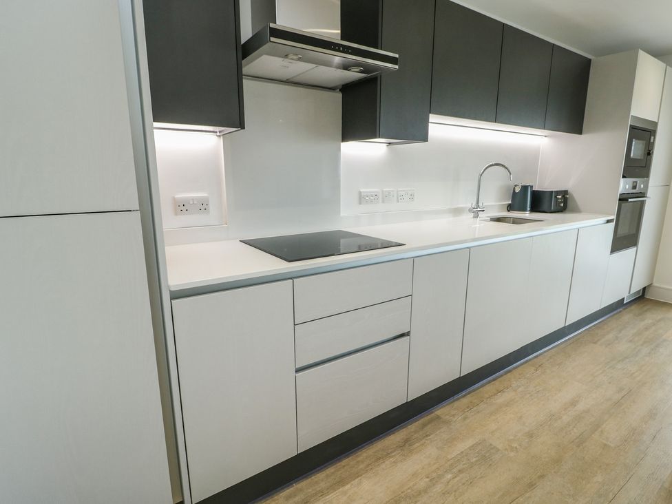 A modern kitchen with a sink and cooktop at Glynllifon 5 Marian-glas near Benllech