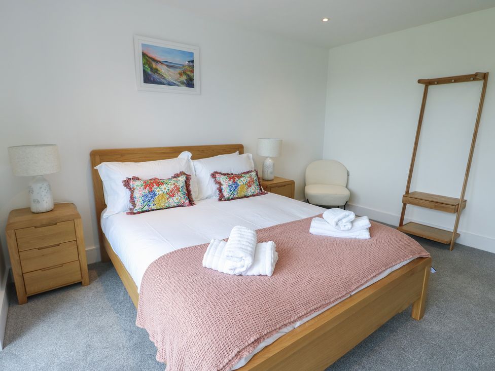 A bedroom with a bed and bedside tables at Glynllifon 5 Marian-glas near Benllech