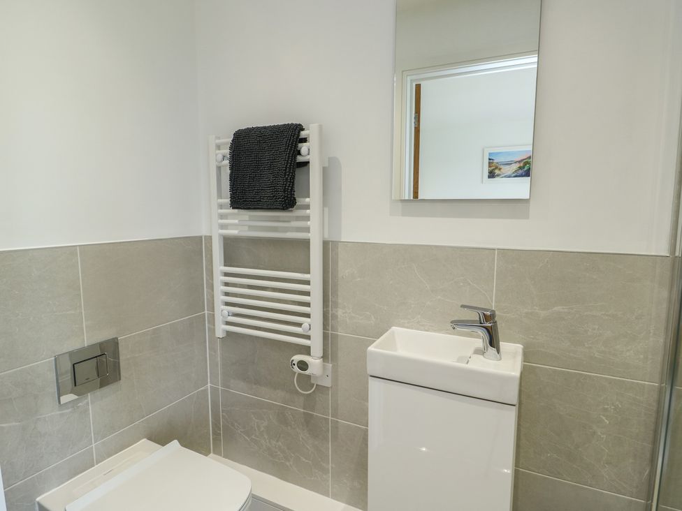 A bathroom with a toilet and hand basin at Glynllifon 5 Marian-glas near Benllech