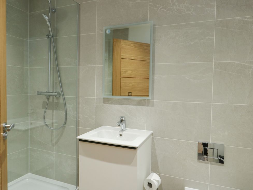 A bathroom with a shower and sink at Glynllifon 5 Marian-glas near Benllech