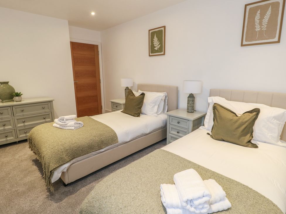 A bedroom with twin beds and a dresser at Glynllifon 5 Marian-glas near Benllech