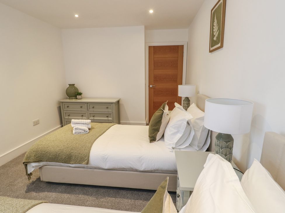A bedroom with two beds and a dresser at Glynllifon 5 Marian-glas near Benllech